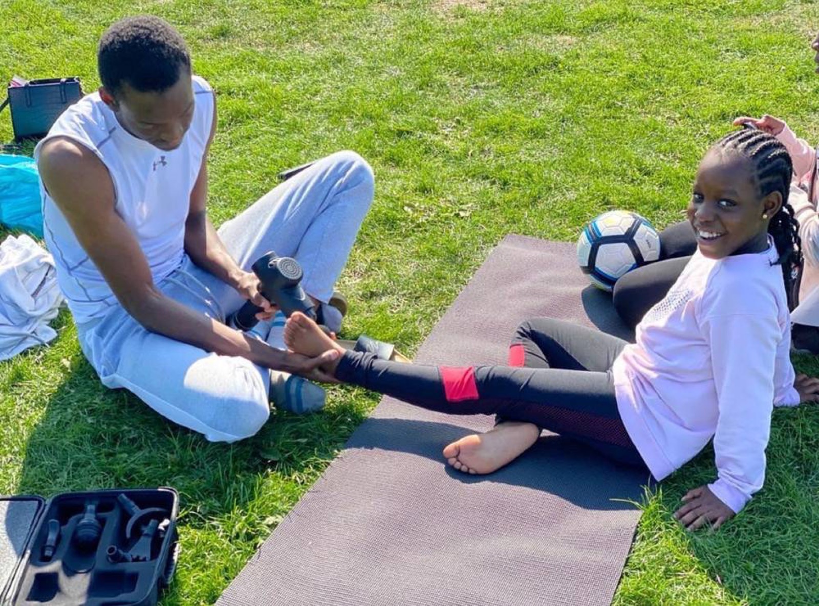 Hisham coaching a young athlete through a stretch: kids personal training in London